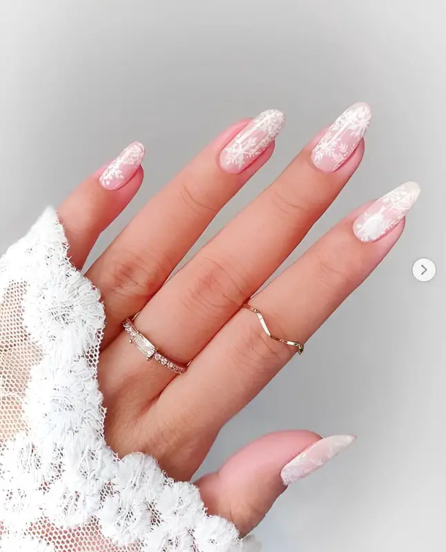 Mulher com unhas de natal brancas com flocos de neve.