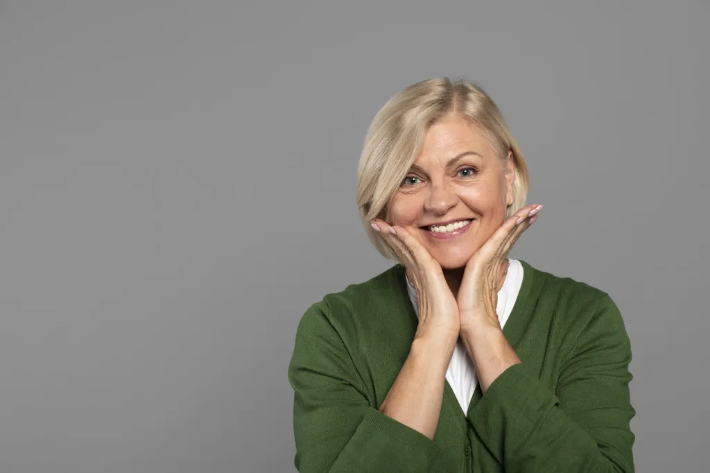 Mulher com as mãos no rosto sorrindo